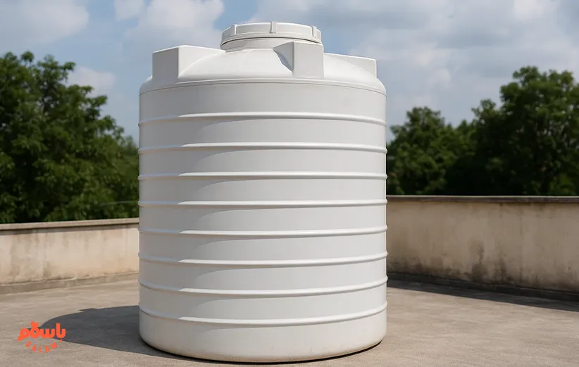 مخزن آب پلاستیکی سفید رنگ از نوع پلی‌اتیلن سه‌لایه ایستاده، نصب‌شده روی پشت‌بام ساختمان برای ذخیره‌سازی آب شرب